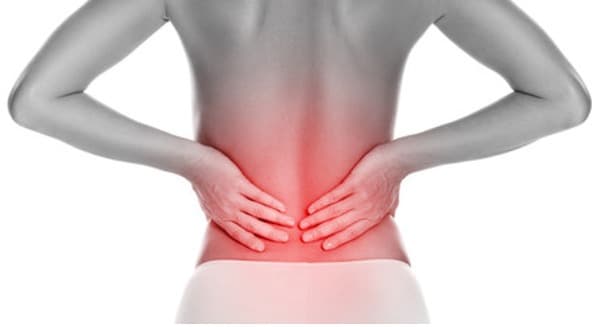 Person holding lower back while considering pain management